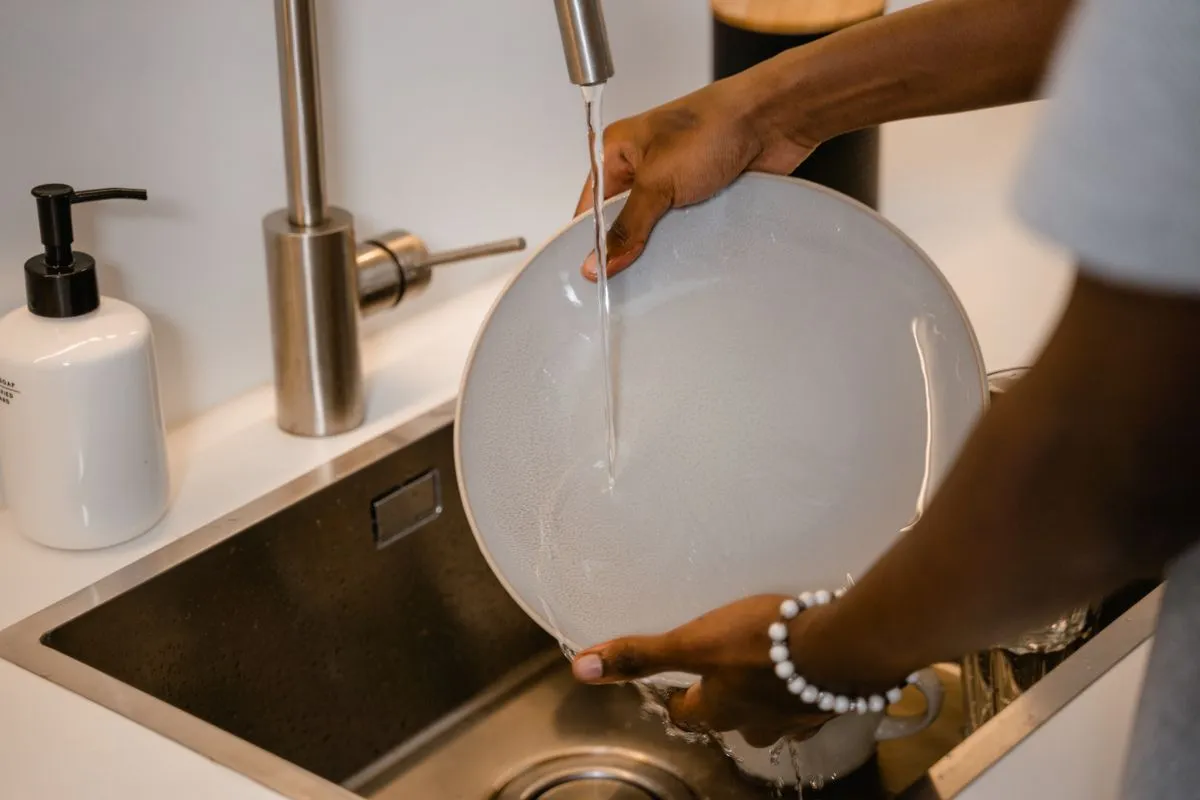 Technician repairing a dishwasher in a modern kitchen