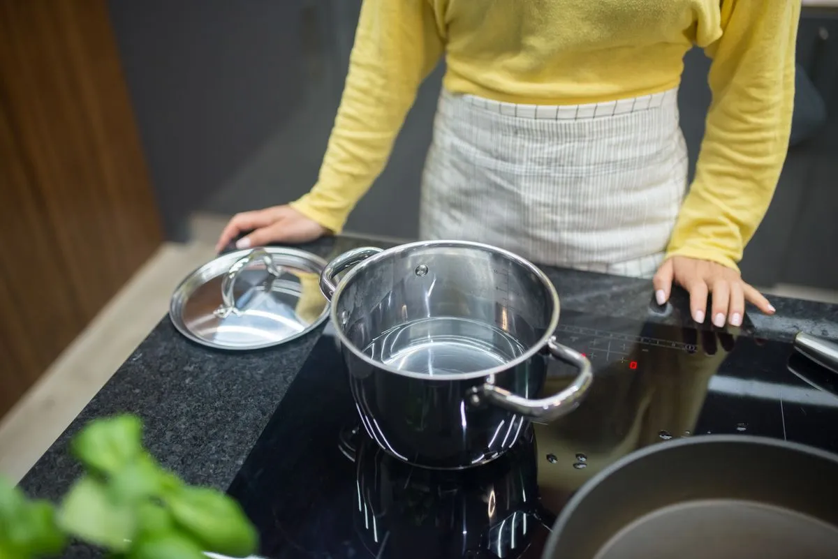 Technician performing oven repair service in a modern kitchen