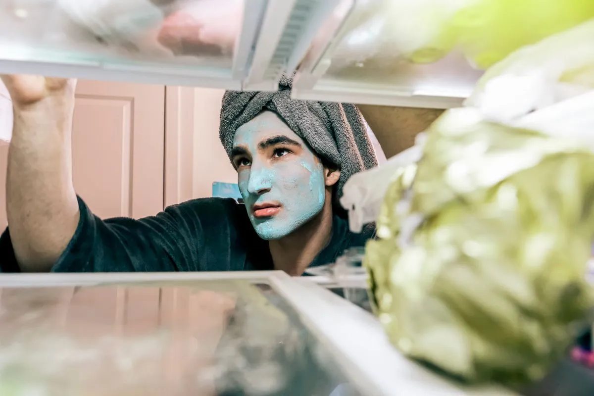 Technician inspecting refrigerator repair components in a kitchen