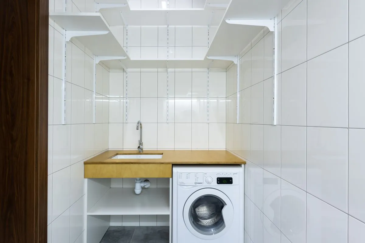 Technician diagnosing a washer and dryer repair in a laundry room