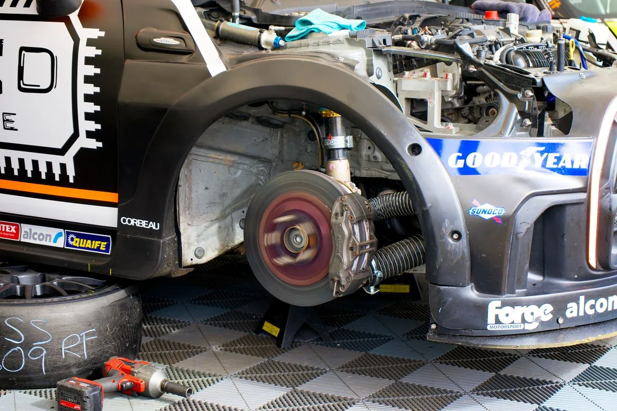 Brake technician measuring pad thickness during a brake repair service