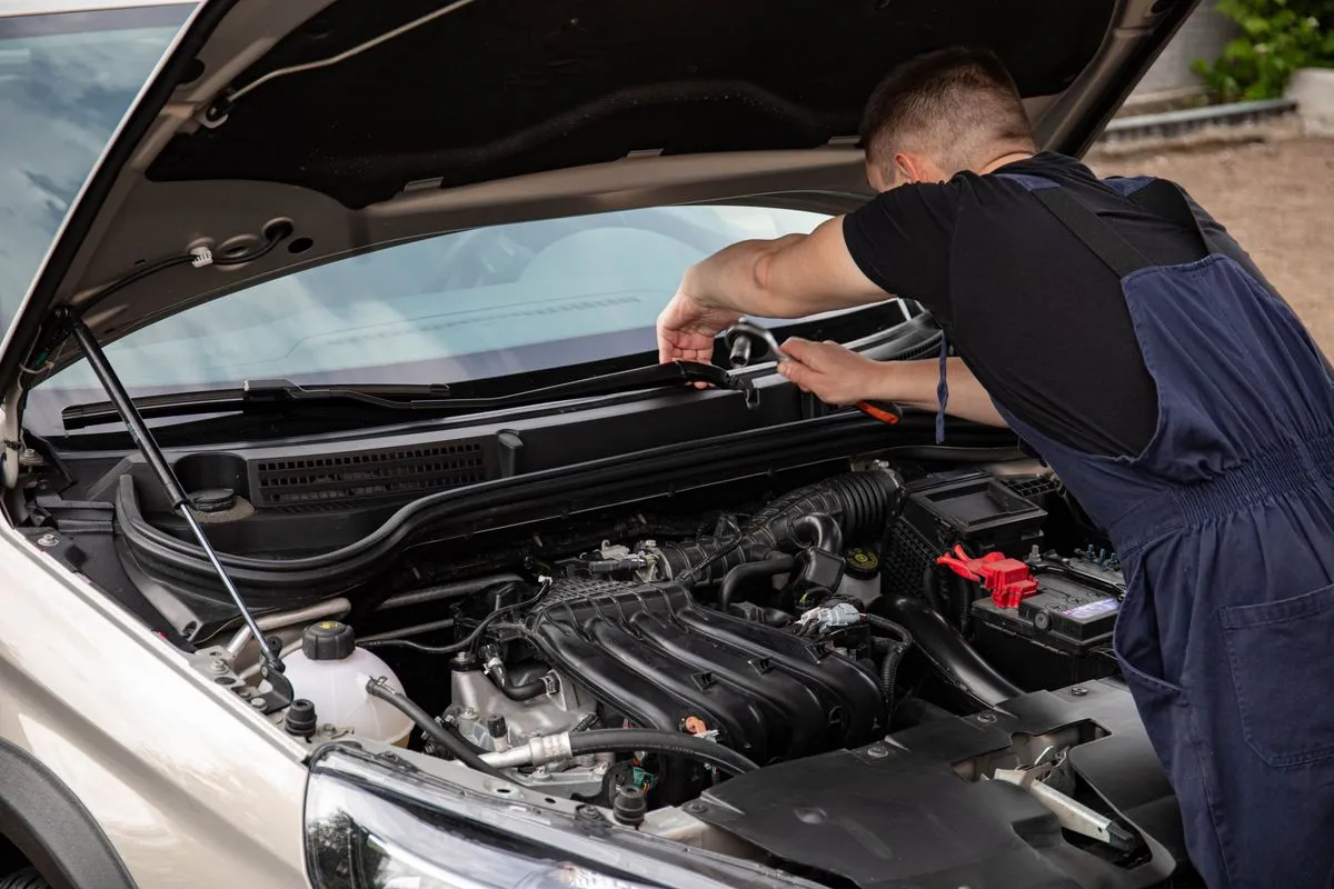Technician performing car AC repair in a workshop