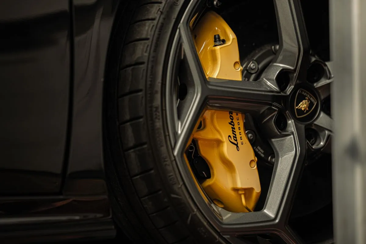 Technician performing wheel alignment service in a modern tire shop