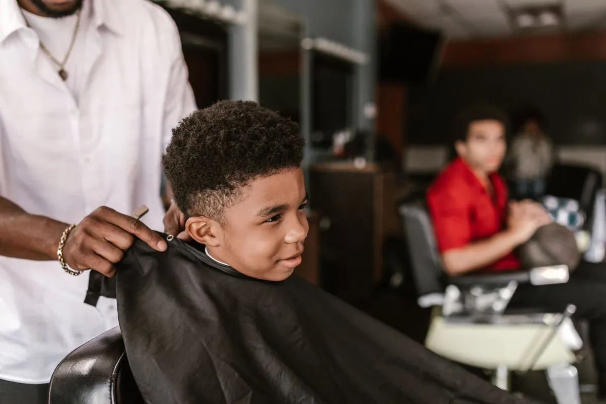 A smiling child getting a neat haircut in a family barbershop