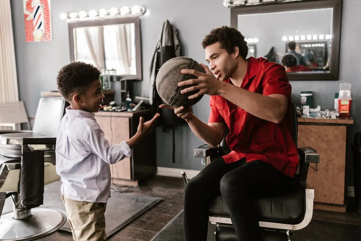 A barber finishing details on a school-ready children's haircut