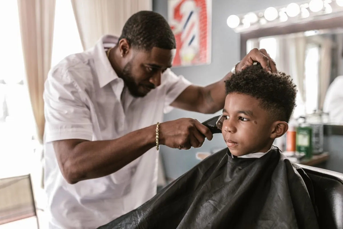 Happy child receiving a haircut in a family barbershop