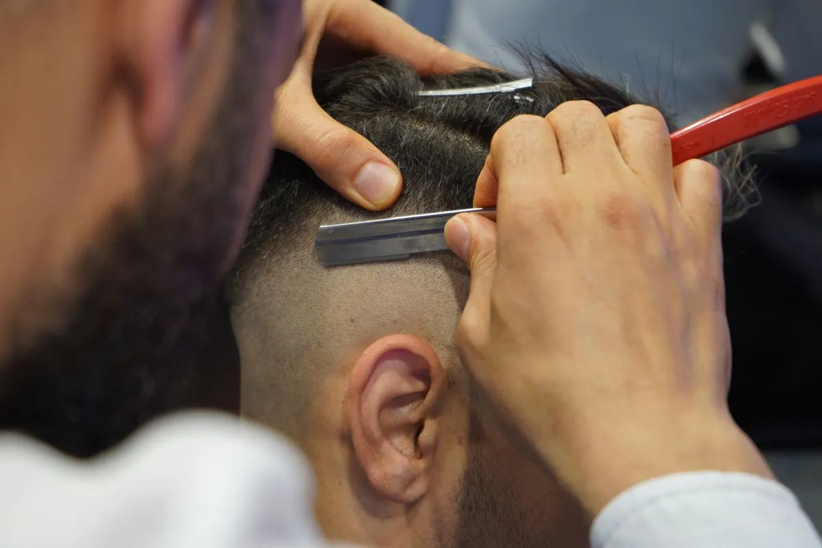Barber shaping a modern men's haircut in a classic barber shop