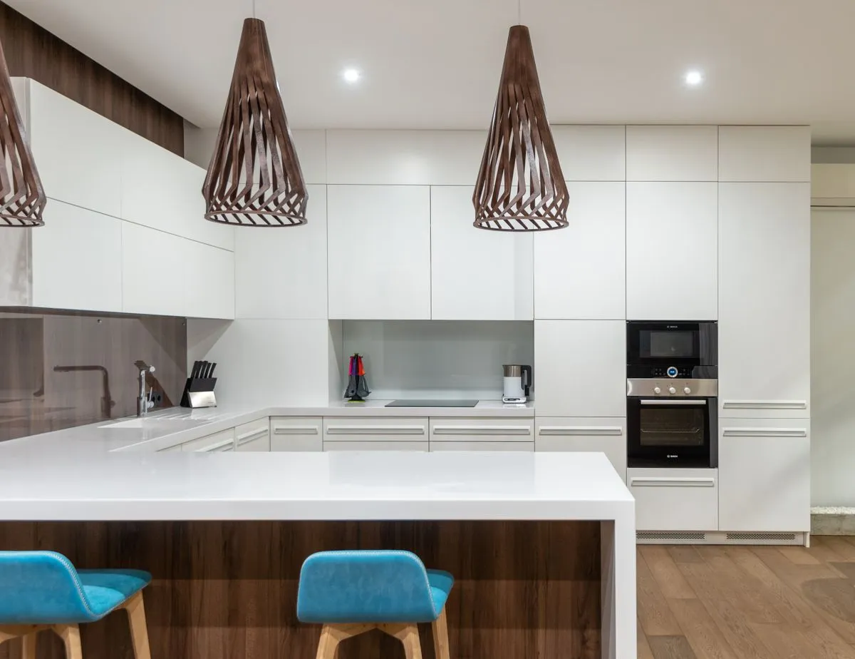 Warm wood kitchen cabinet installation with a large island and pendant lighting