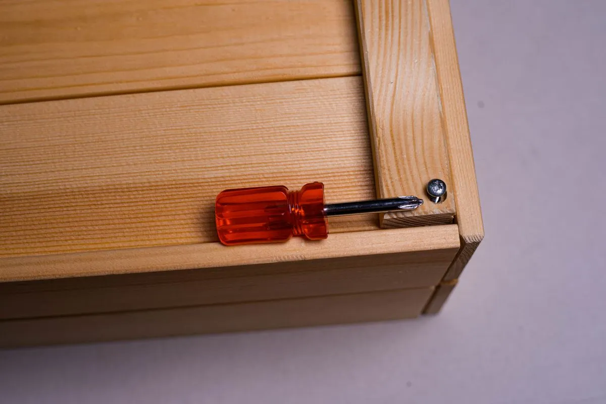 Technician checking drawer alignment during dresser assembly
