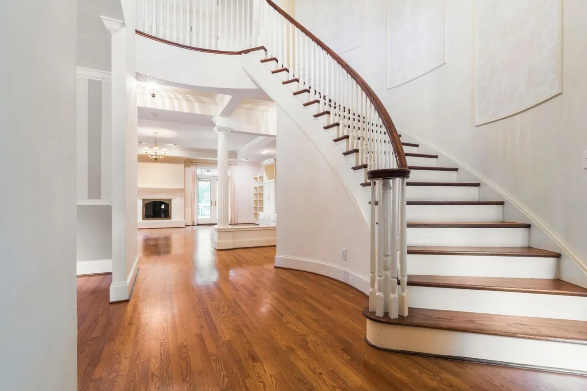 Custom wood staircase with oak treads and painted risers in a bright foyer