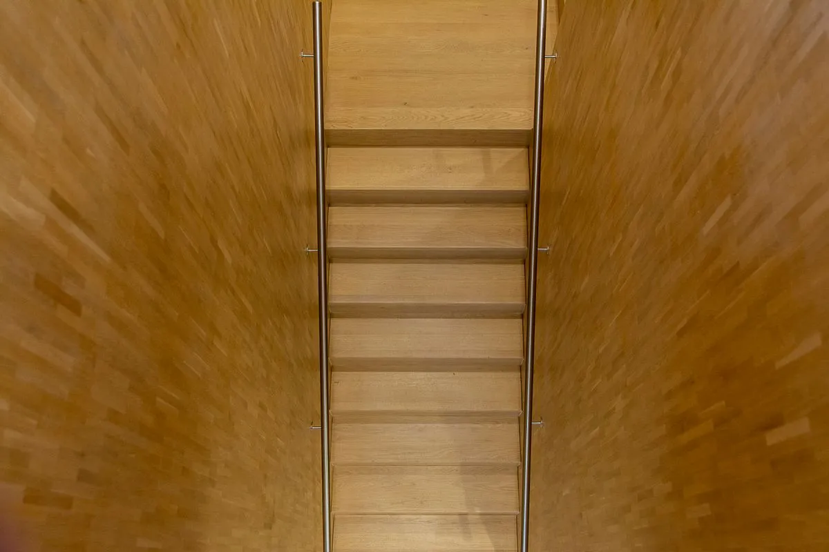 Renovated interior staircase with stained hardwood treads and clean white trim