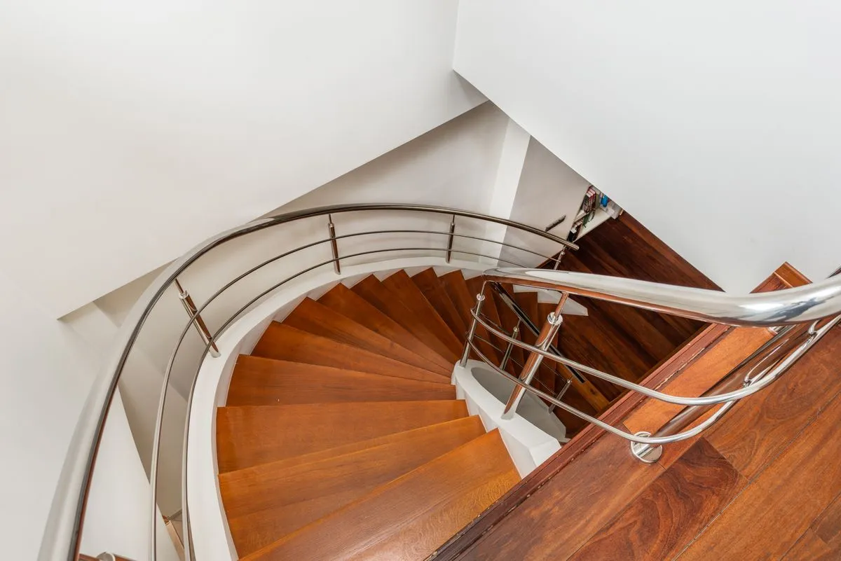 Elegant custom wood staircase with hardwood treads and white trim in a modern American home