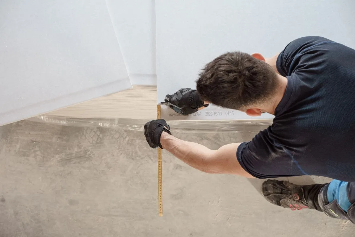 Drywall contractor taping seams and preparing a wall for a smooth finish