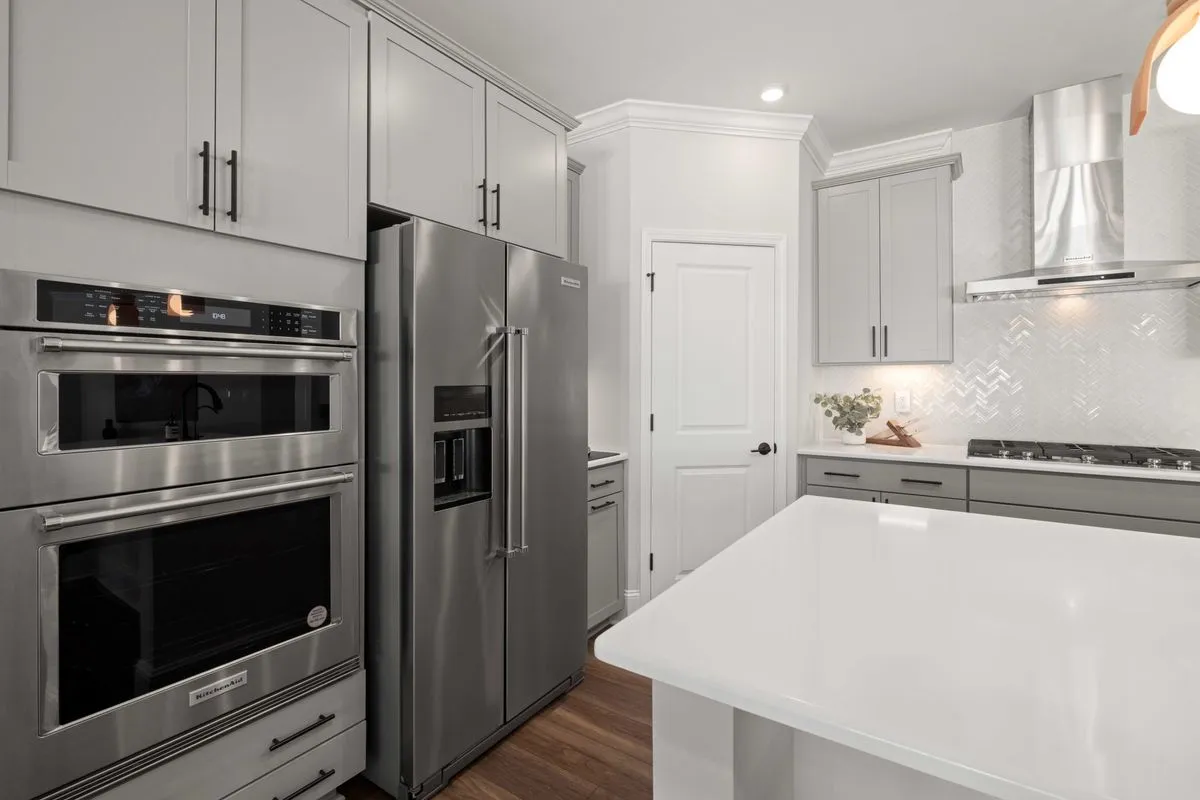 Open-concept kitchen remodeling with warm wood floors and tile backsplash