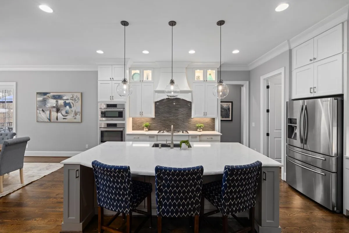 Modern remodeled kitchen with white cabinets, quartz countertops, and warm wood accents