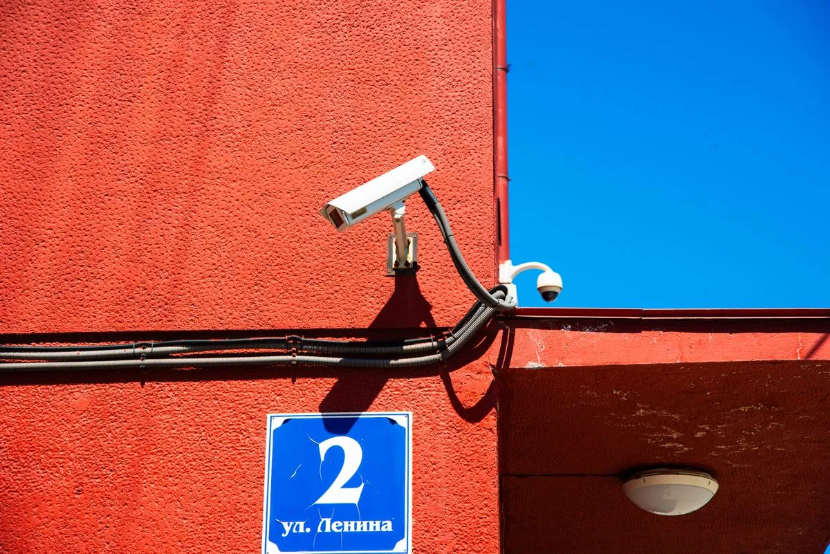 Technician installing outdoor surveillance cameras on a residential property