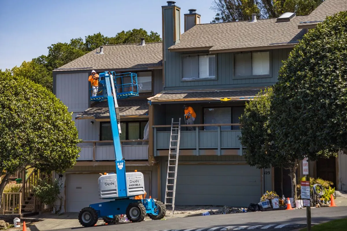 Exterior painting service on cedar siding with masked windows and clean ladder setup