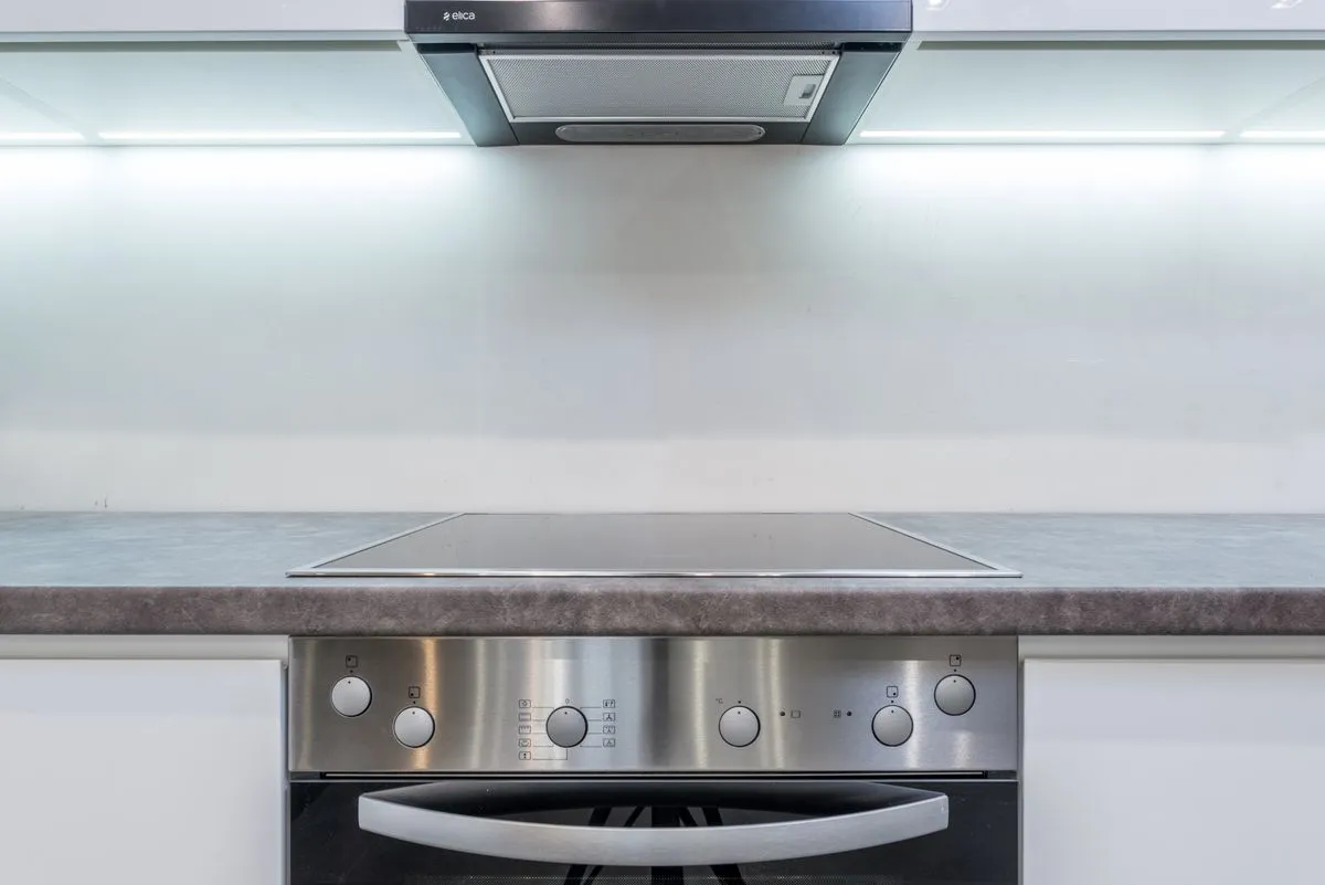 Técnico realizando assistência técnica de fogão e micro-ondas em cozinha residencial