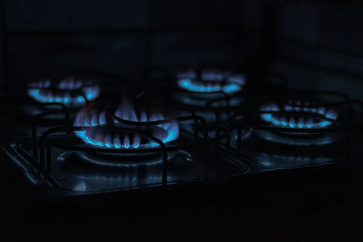 Técnico realizando assistência técnica de fogão e micro-ondas em cozinha residencial