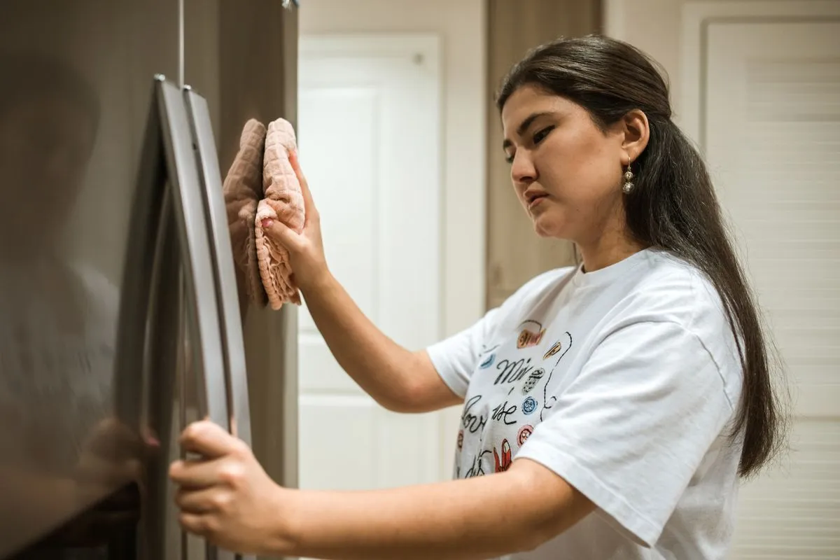 Técnico de refrigeração fazendo conserto de geladeira em cozinha residencial