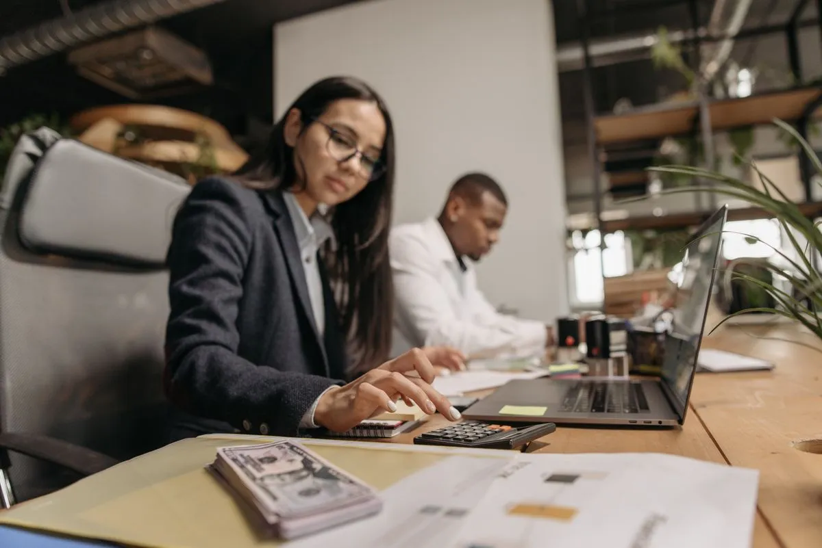 Mesa de atendimento com relatórios e notebook em ambiente de contabilidade digital