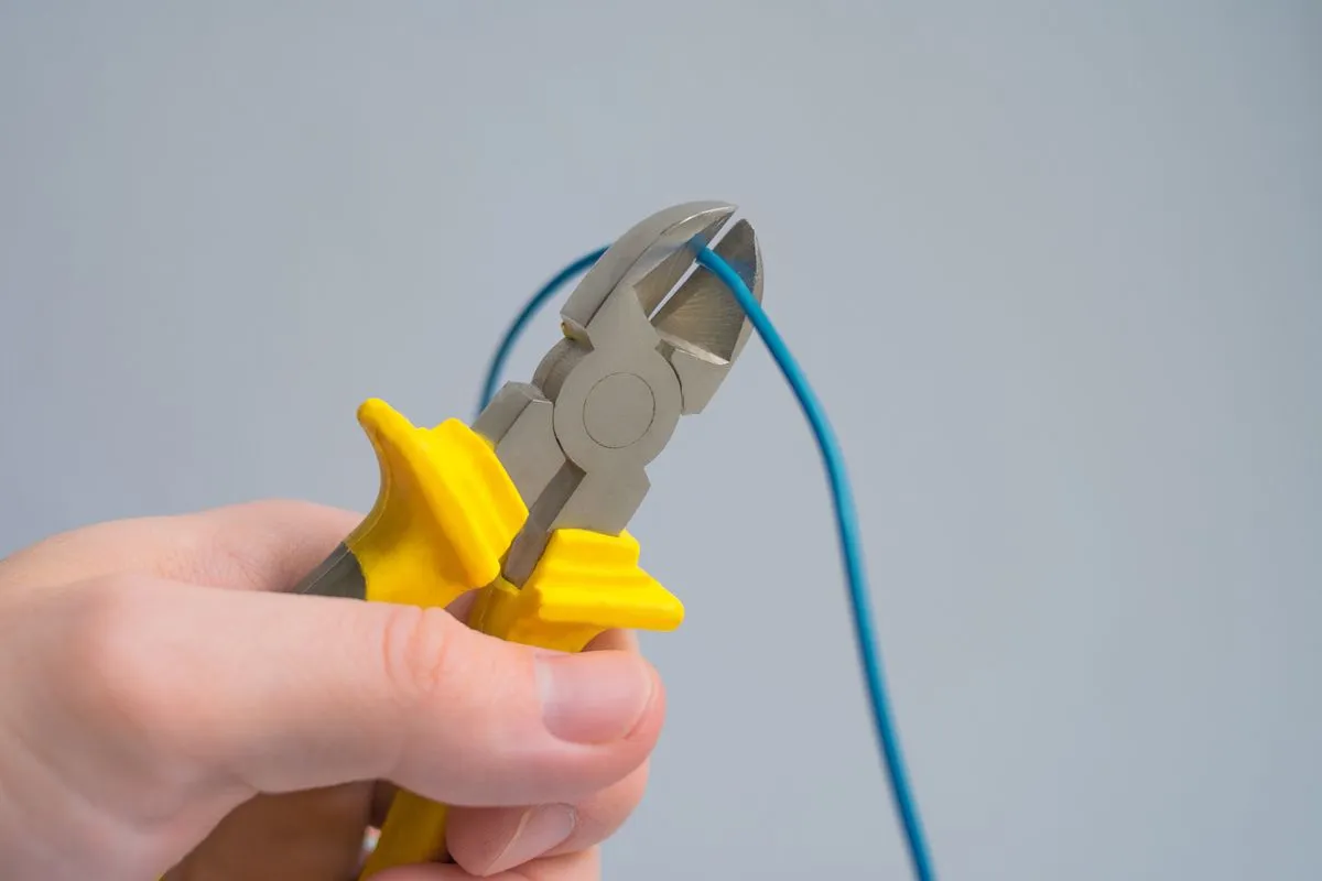 Eletricista realizando instalação elétrica residencial em quadro de distribuição
