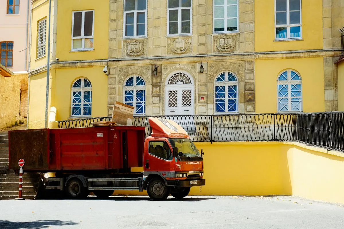 Retirada de entulho de obra com caminhão em rua urbana