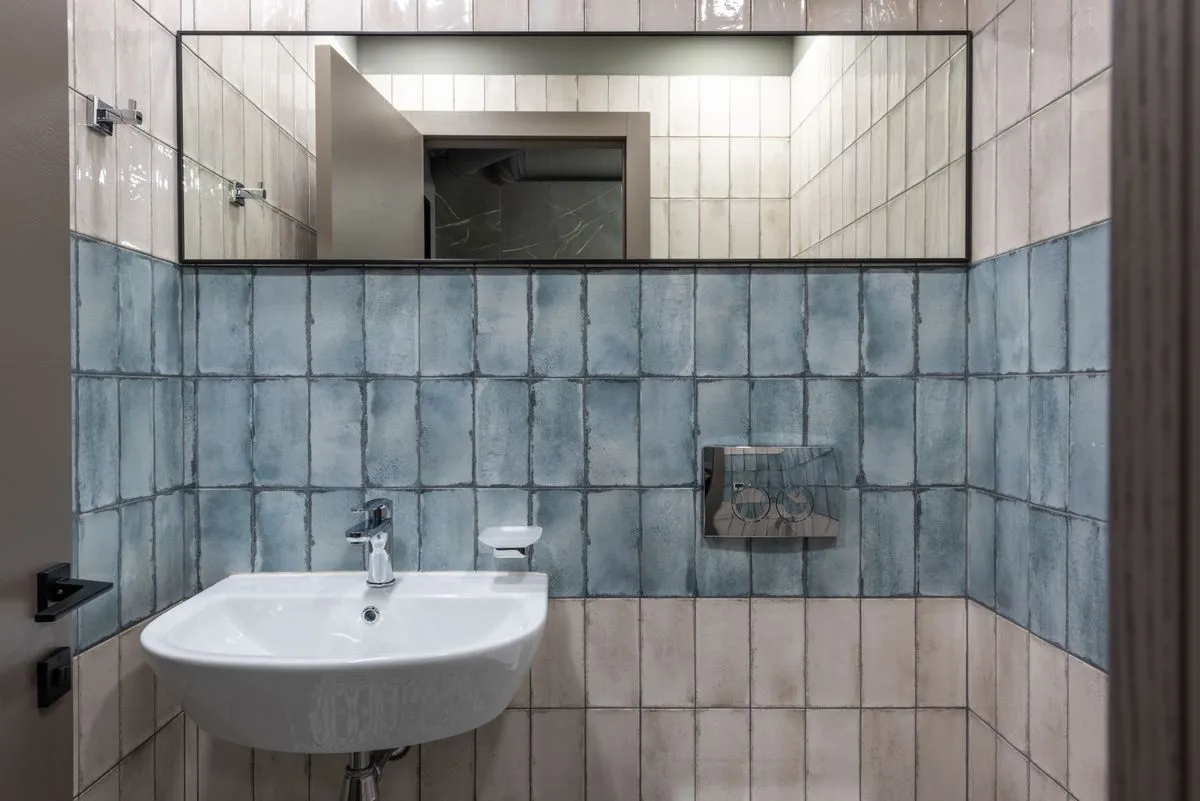 Profissional usando nível durante colocação de azulejo na parede