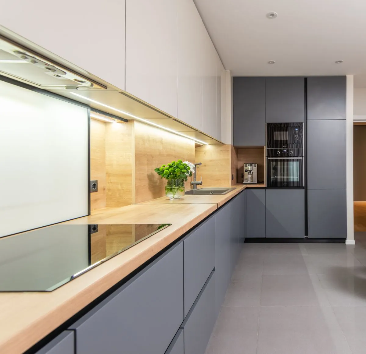 Cozinha planejada moderna com armários sob medida e iluminação integrada