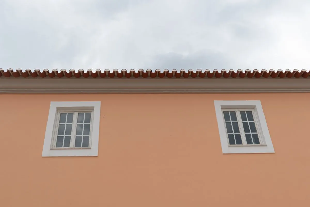 Pintor residencial aplicando tinta branca em parede interna de casa